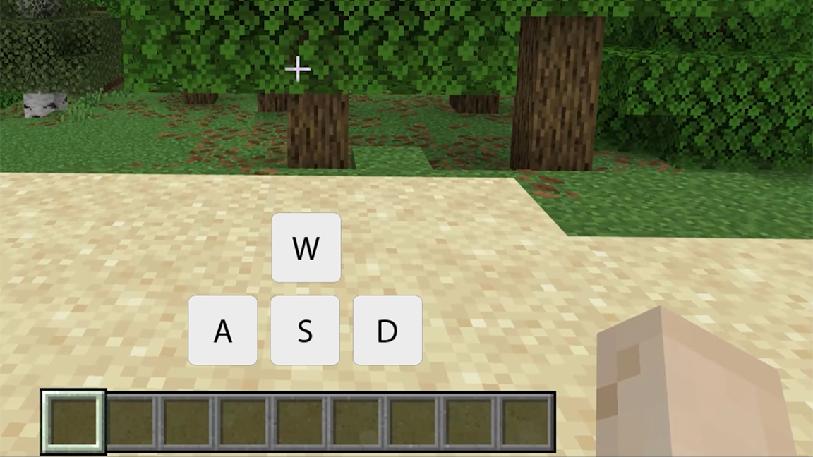 Mondo di Minecraft Education con alberi e sabbia con tasti WASD per lo spostamento.